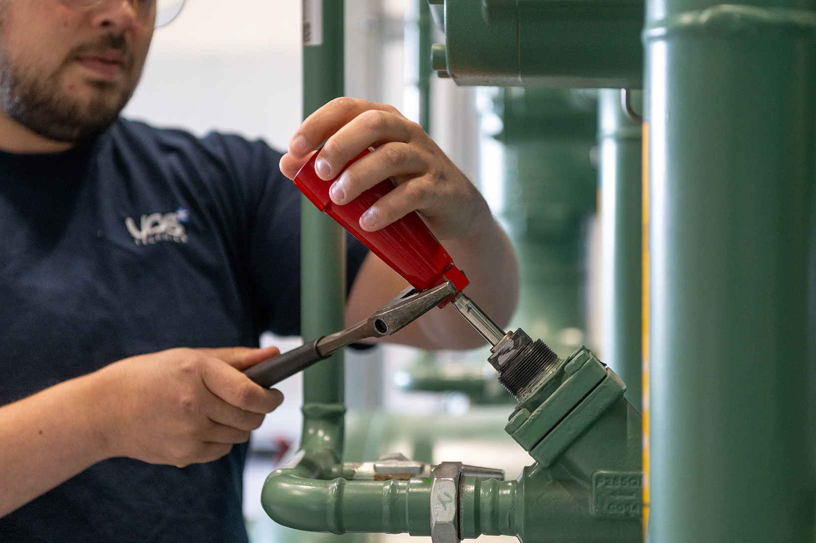 MEdewerker van Vos Technics die een stuurhendel installeert op een groen leiding.